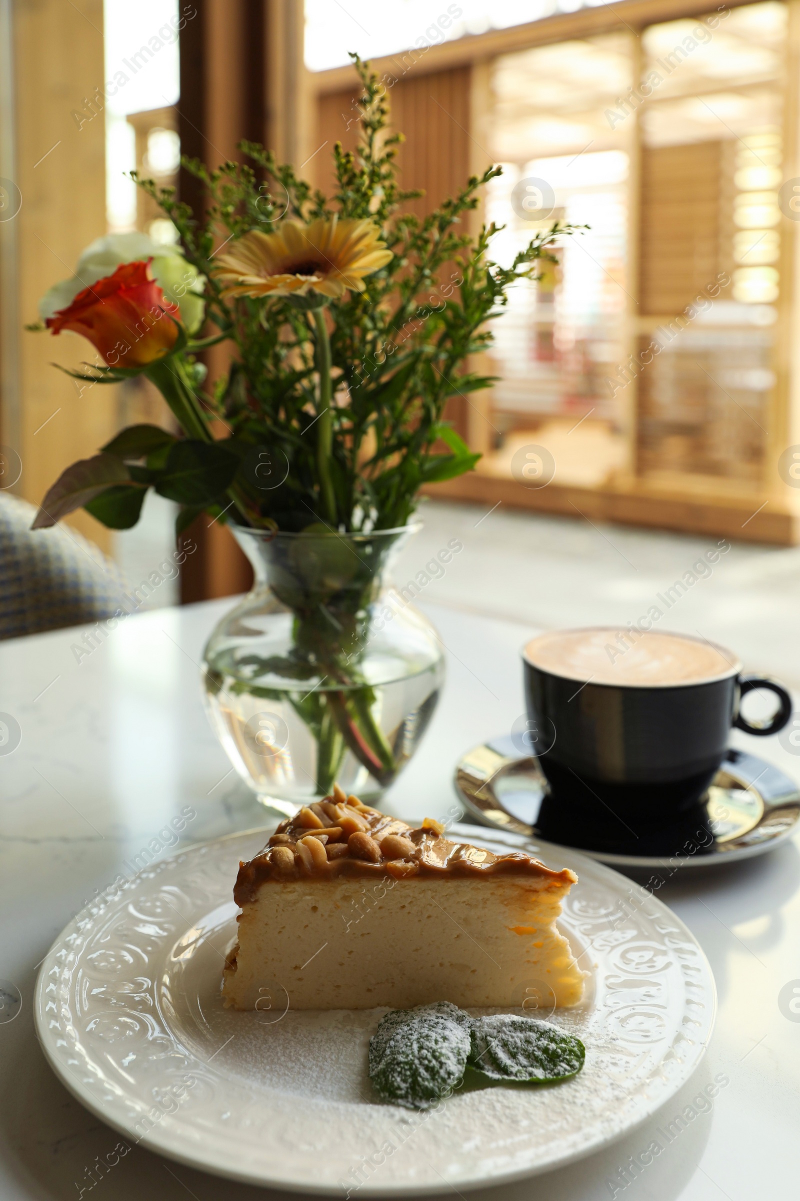 Photo of Tasty dessert and cup of fresh coffee on table in cafeteria