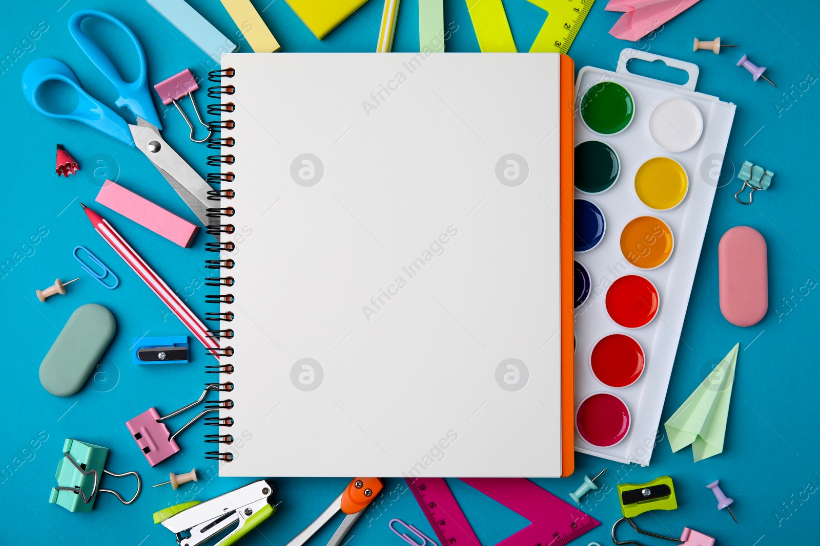 Photo of Different school stationery items and notebook on light blue background, flat lay with space for text. Back to school