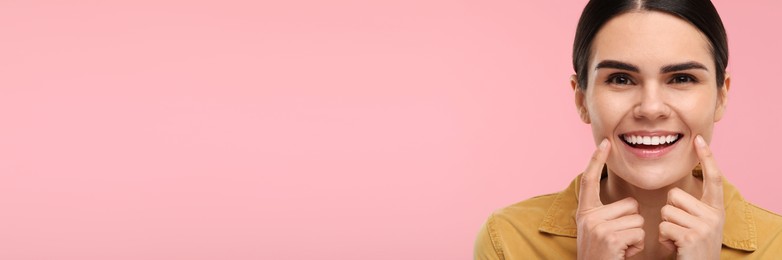 Image of Woman with clean teeth smiling on pink background, space for text. Banner design