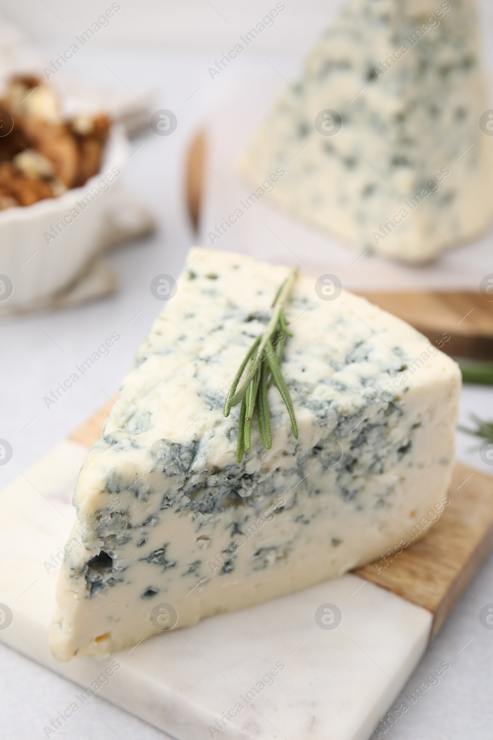 Photo of Tasty blue cheese with rosemary on light table