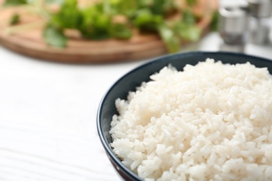 Photo of Bowl of boiled rice on table, closeup. Space for text