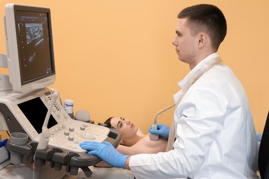 Photo of Mammologist conducting ultrasound examination of woman's breast in clinic