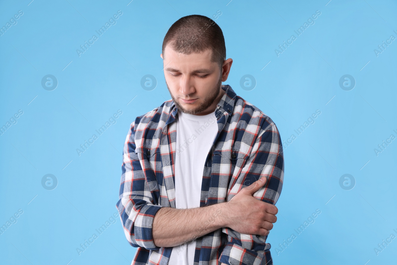 Photo of Upset man in shirt on light blue background