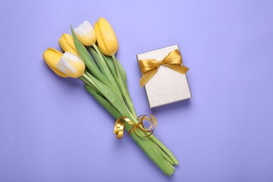 Bouquet of tulips and gift box on light purple background, flat lay