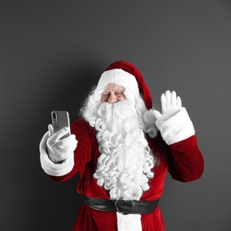 Photo of Authentic Santa Claus taking selfie on grey background. Space for text
