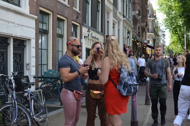 AMSTERDAM, NETHERLANDS - AUGUST 06, 2022: People in bright clothes at LGBT pride parade on sunny day