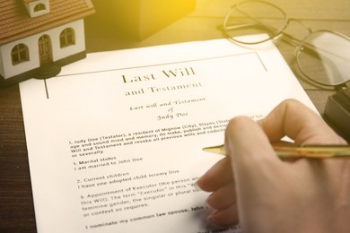 Woman reading Last Will and Testament at table, closeup