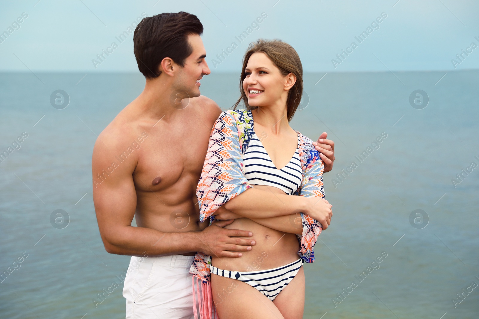 Photo of Happy young couple spending time together on sea beach