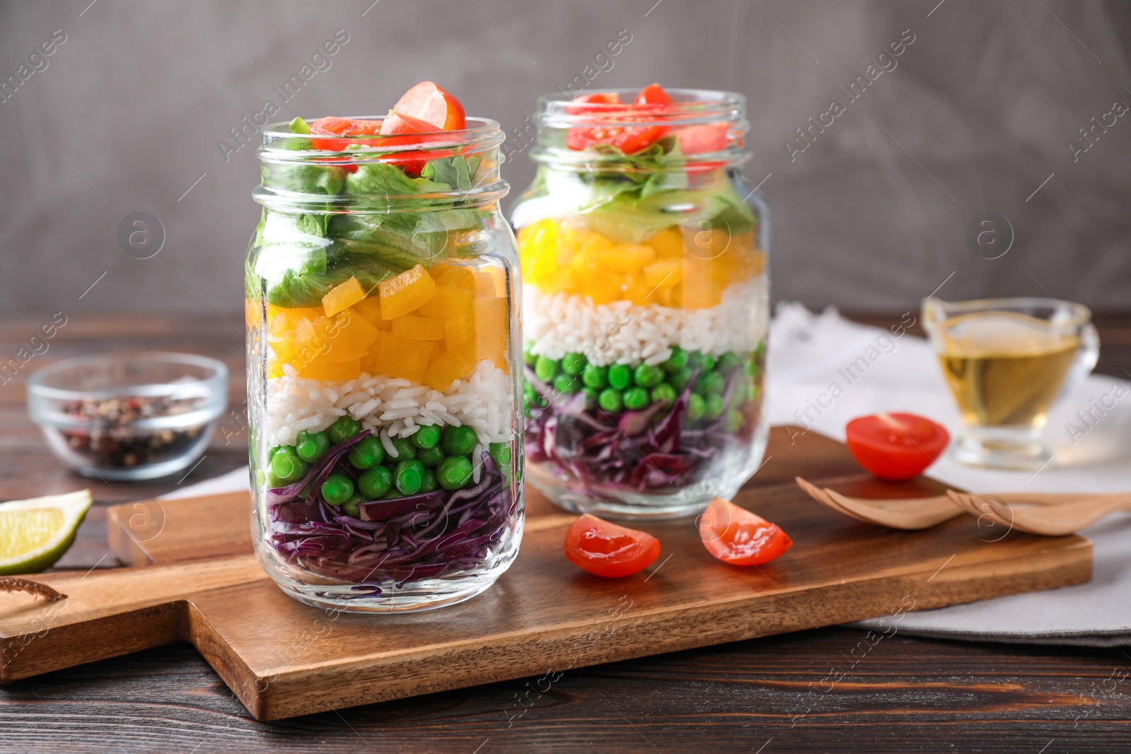 Photo of Healthy salad in glass jars on wooden table