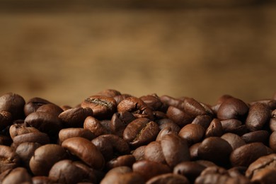 Photo of Heap of aromatic roasted coffee beans, closeup