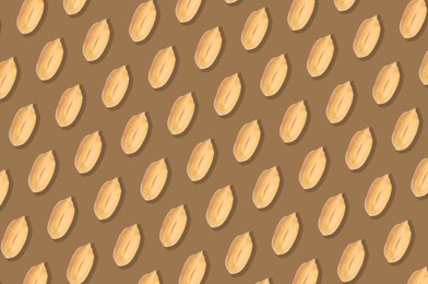 Pattern of peeled peanuts on brown background