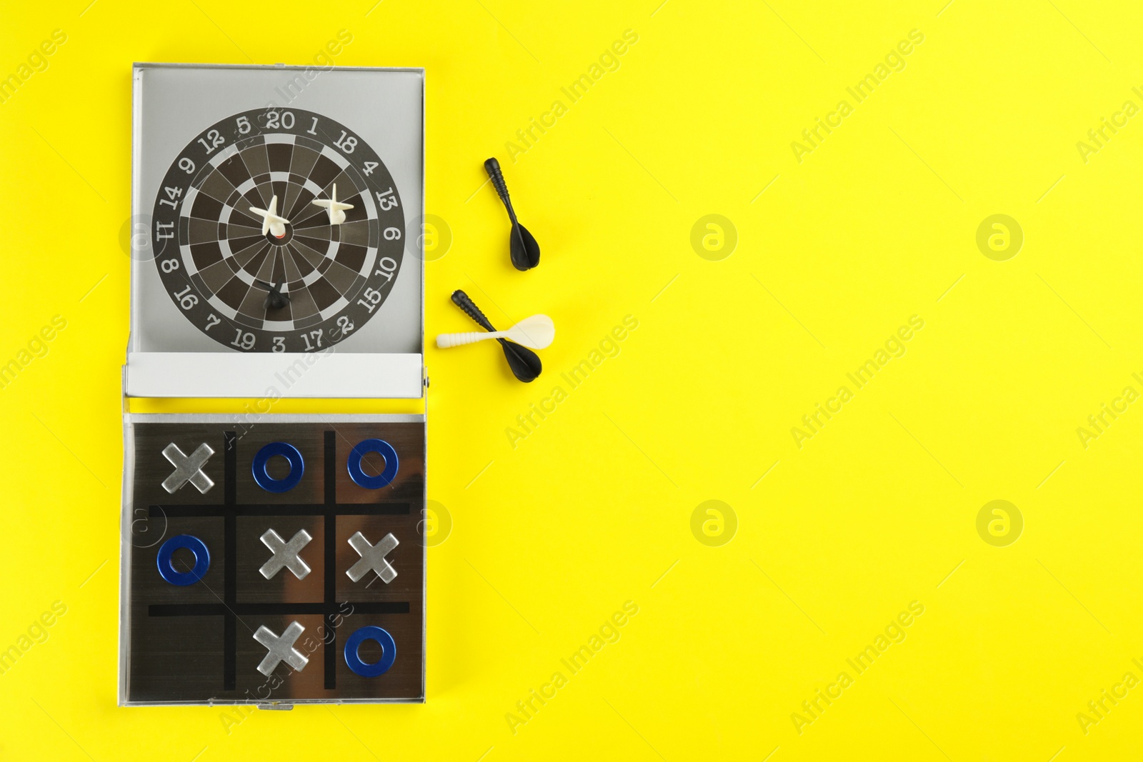 Photo of Board games on yellow background, flat lay. Space for text