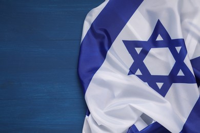 Photo of Flag of Israel on blue wooden background, top view and space for text. National symbol