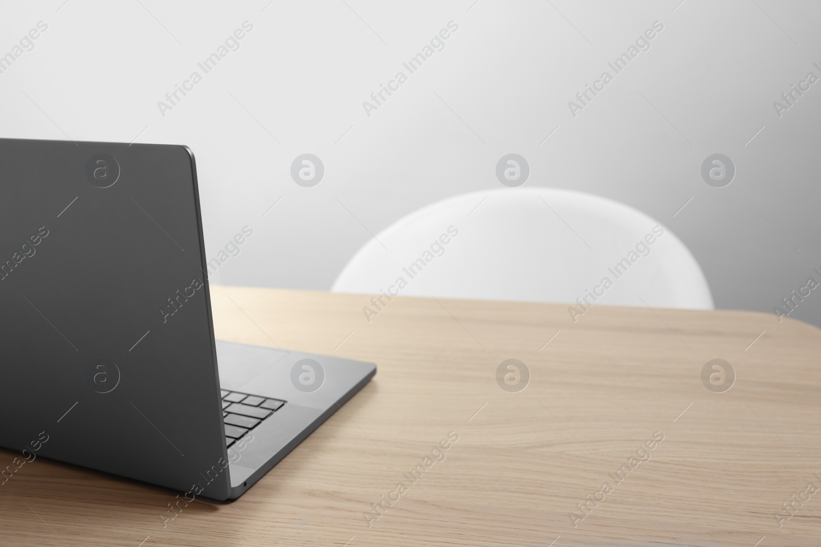 Photo of Stylish modern laptop on wooden table indoors. Space for text