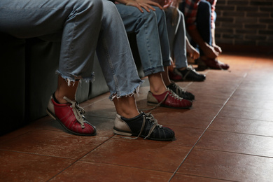 Photo of Friends putting shoes on at n bowling club, closeup of legs