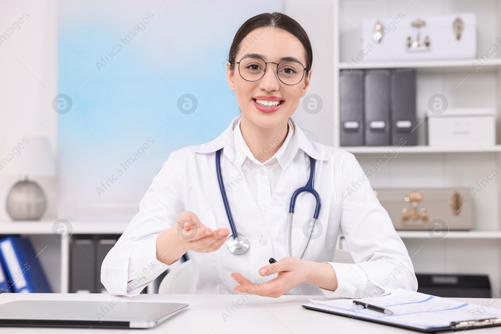 Photo of Medical consultant with stethoscope at table in clinic