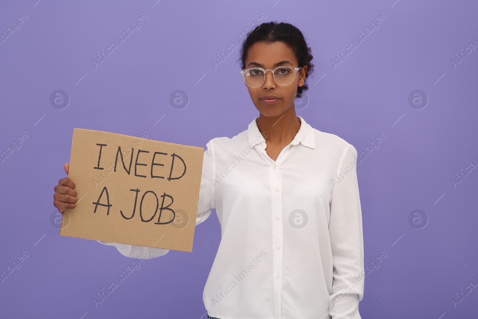 Photo of Unemployed African American woman holding sign with phrase I Need A Job on violet background