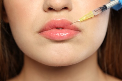 Young woman getting lips injection, closeup. Cosmetic surgery