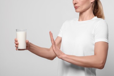 Photo of Woman with glass of milk suffering from lactose intolerance on white background, closeup