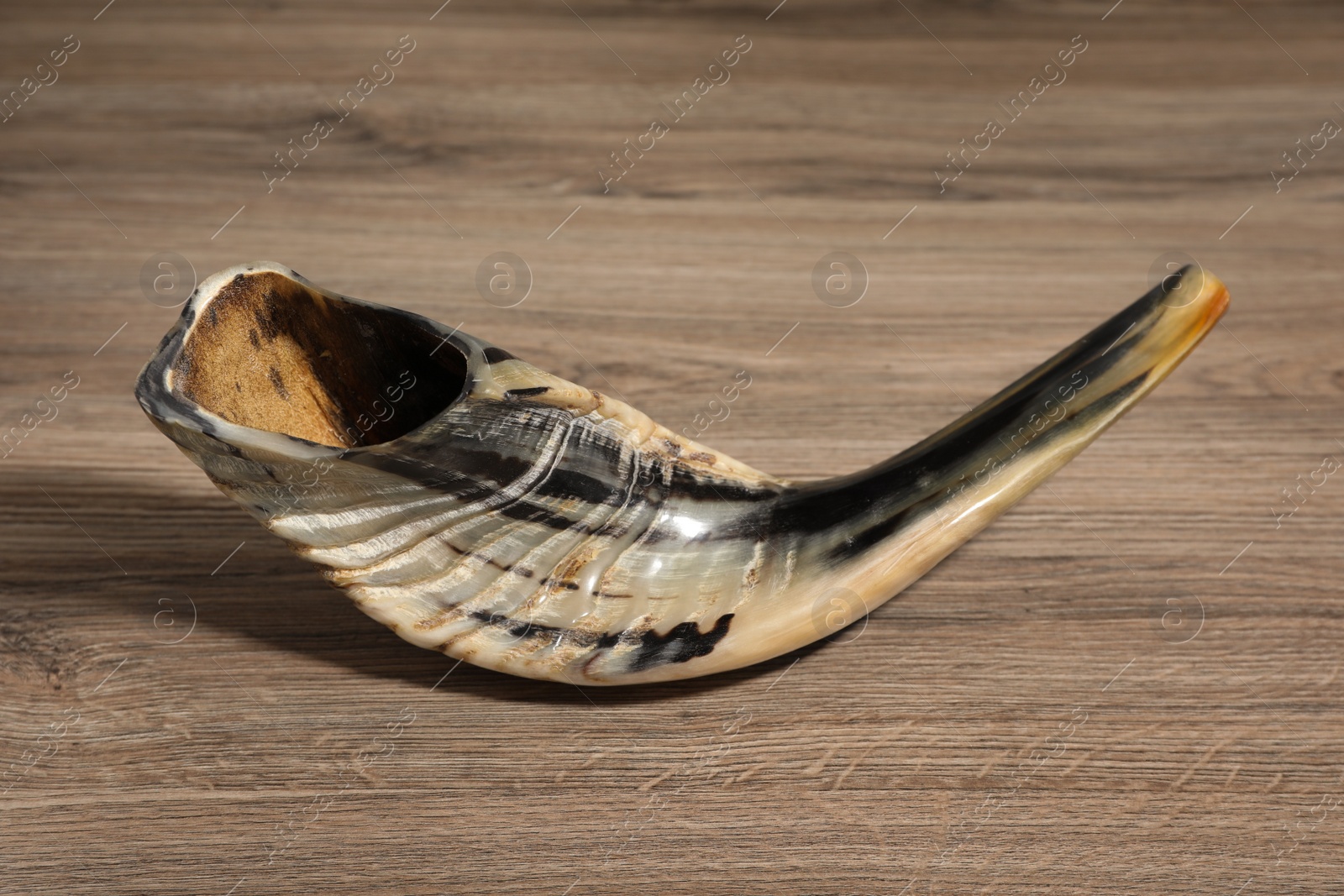 Photo of Shofar on wooden table. Rosh Hashanah holiday symbol