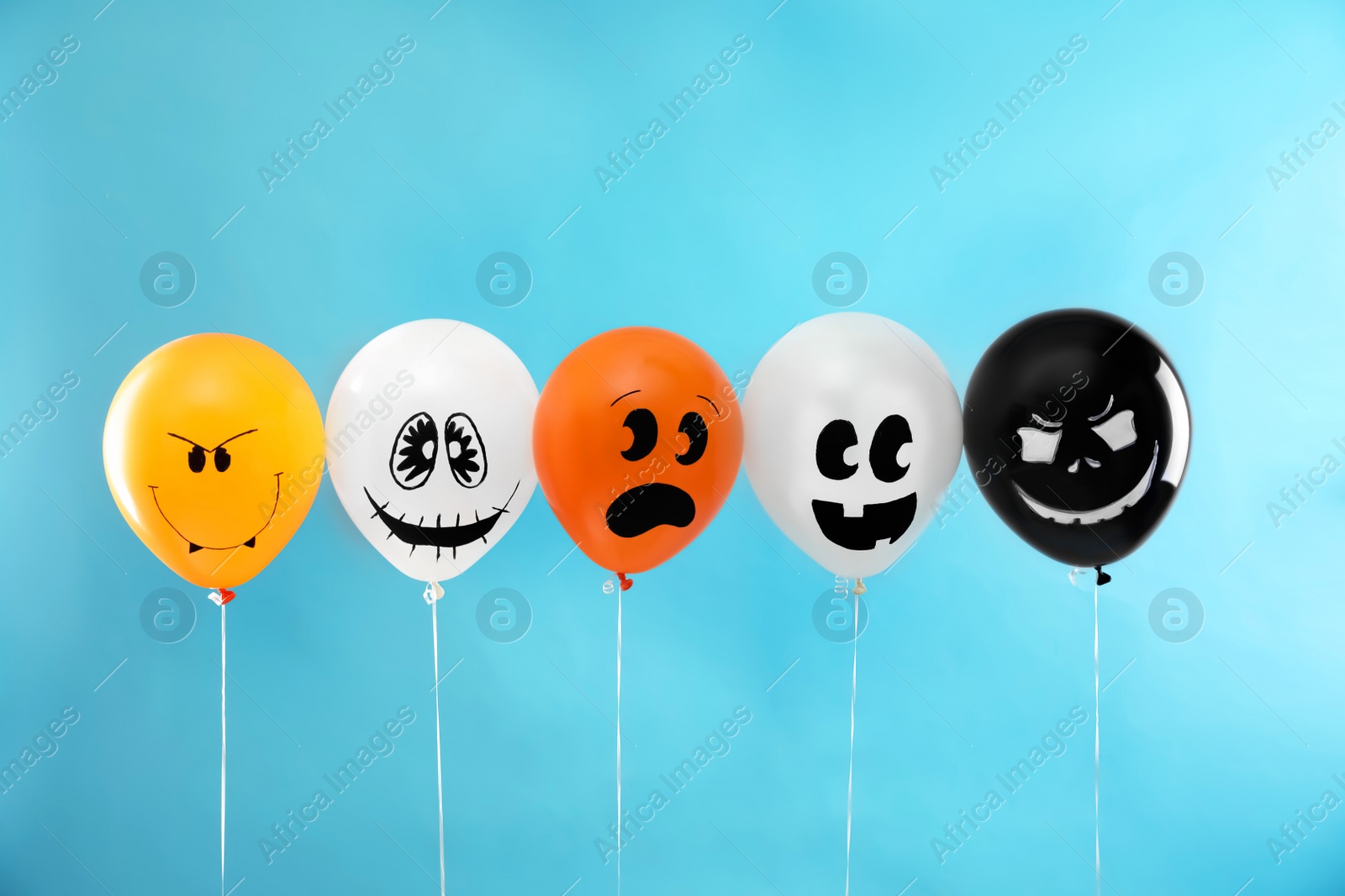 Photo of Spooky balloons for Halloween party on blue background