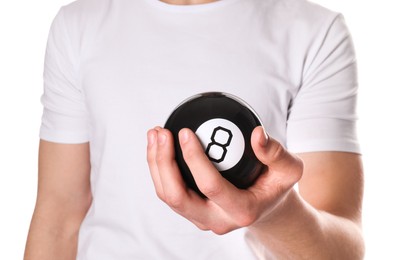 Photo of Man holding magic eight ball on white background, closeup