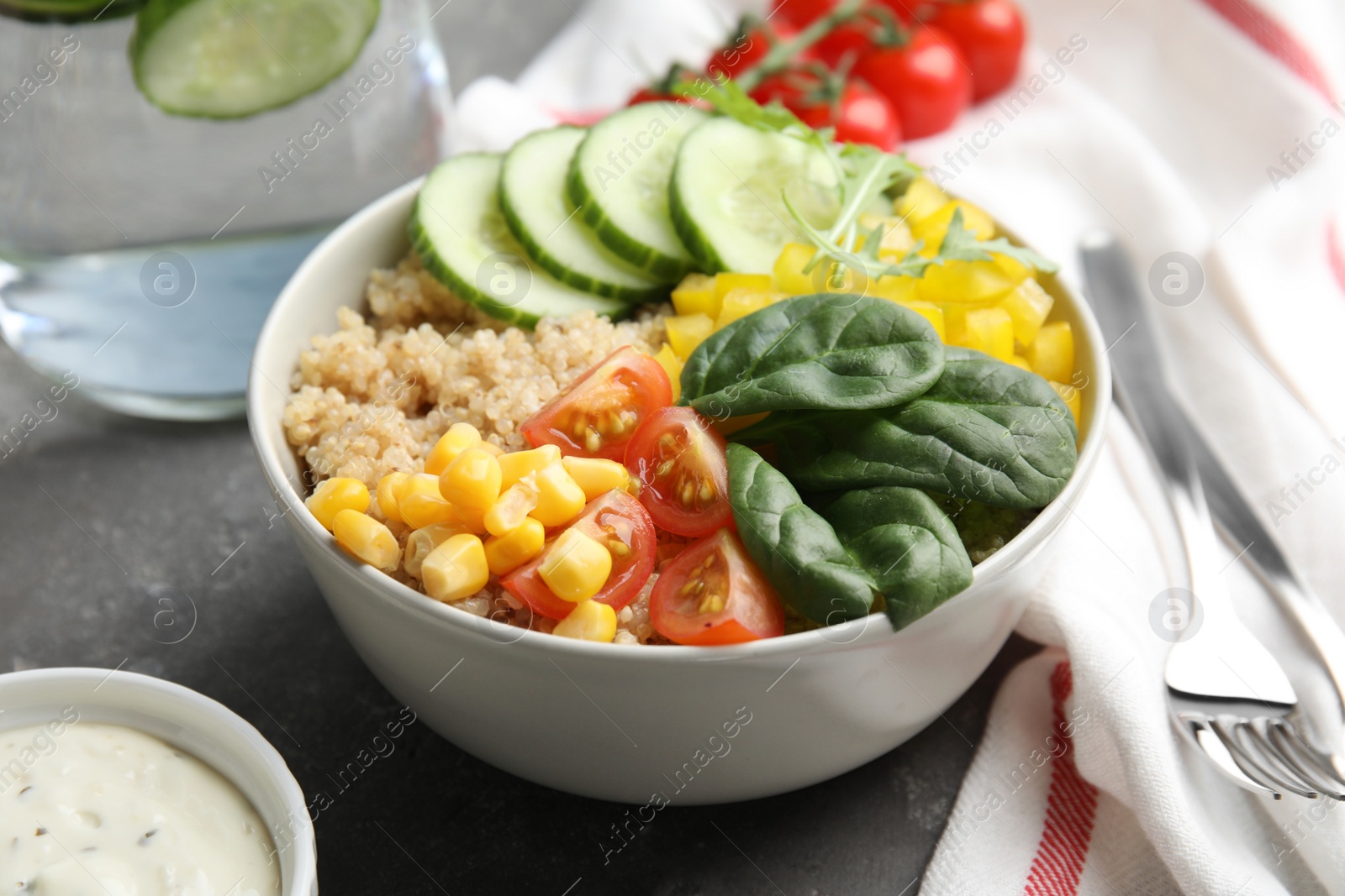 Photo of Healthy quinoa salad with vegetables in bowl on table, closeup