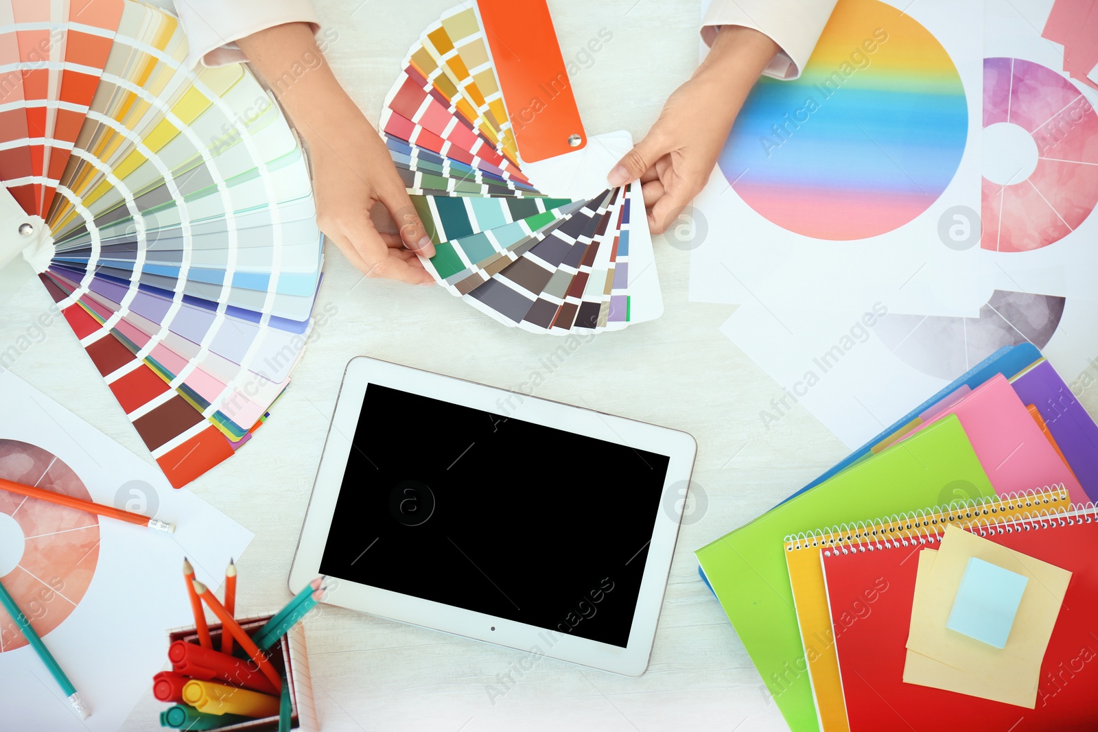 Photo of Woman with paint color palette samples and tablet at table, top view