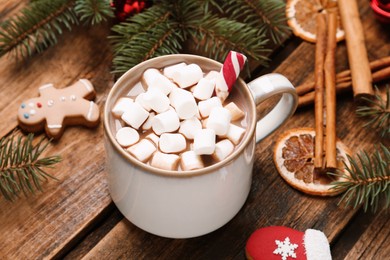 Photo of Delicious hot chocolate with marshmallows and  Christmas cookies on wooden table