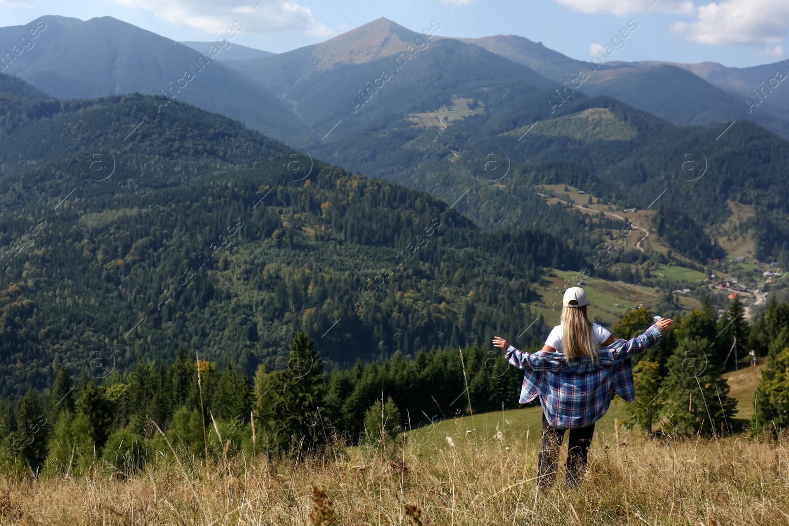 Photo of Woman enjoying picturesque mountain landscape, back view. Space for text