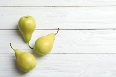 Photo of Ripe pears on wooden background, top view. Space for text