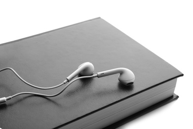 Photo of Bible and earphones on white background, closeup. Religious audiobook