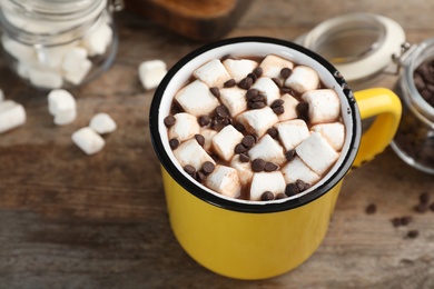 Photo of Cup of chocolate milk with marshmallows on wooden table, closeup