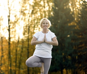 Mature woman practicing yoga outdoors in morning