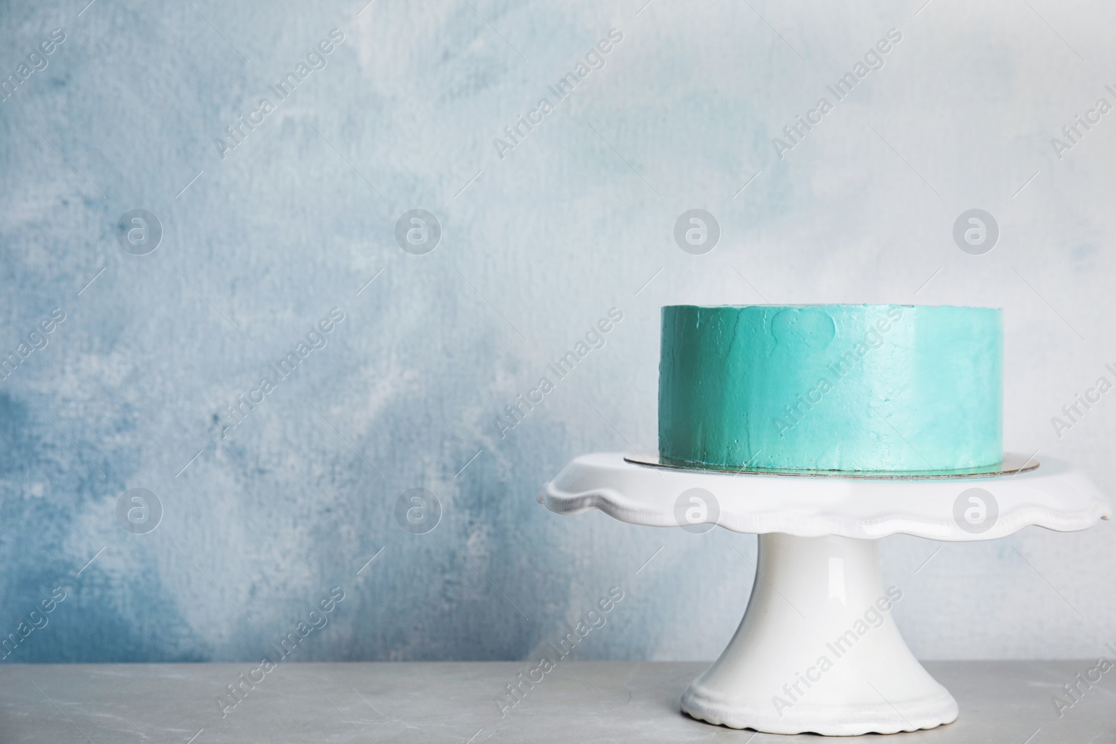 Photo of Fresh delicious birthday cake on stand against color background. Space for text