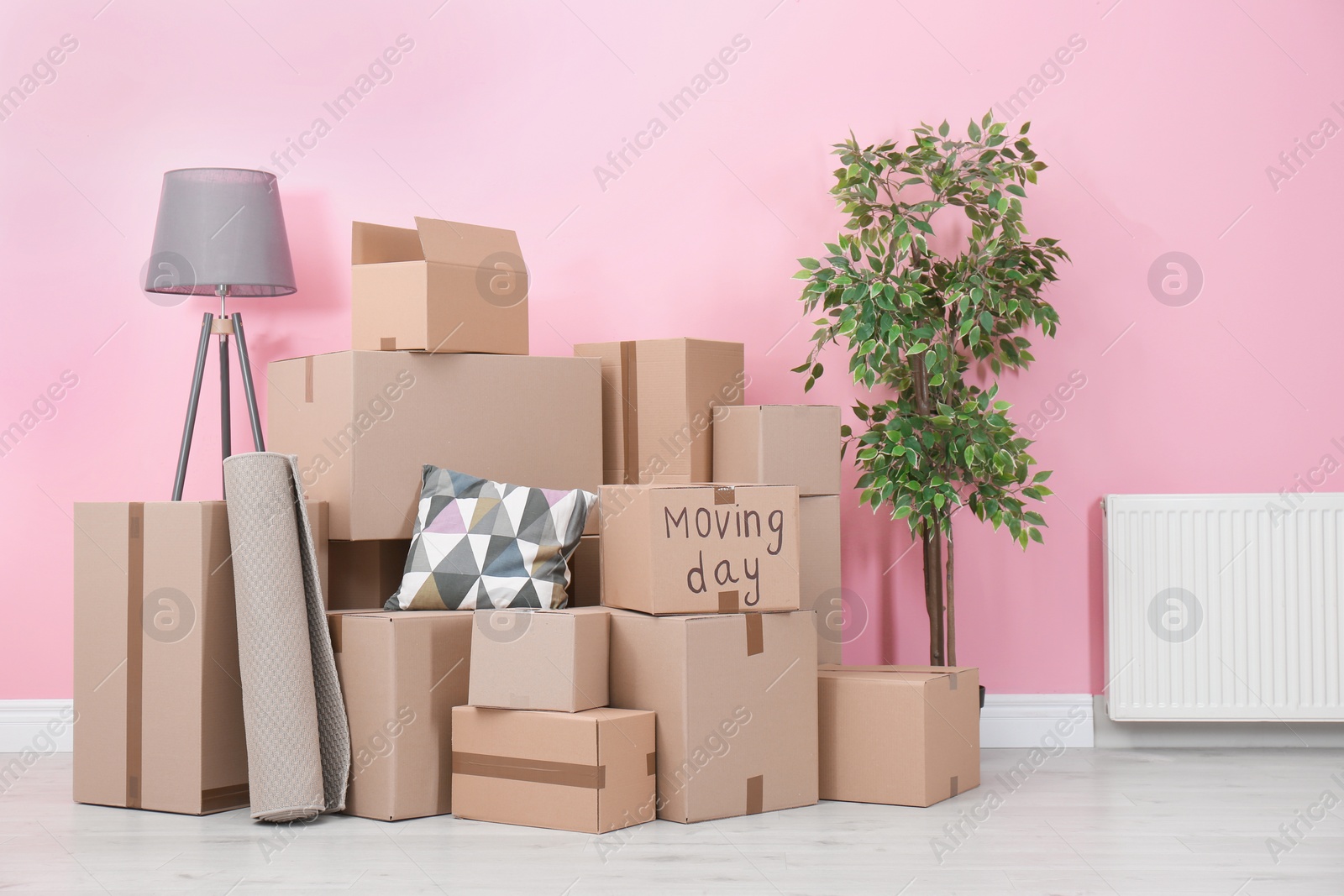 Photo of Cardboard boxes and household stuff in empty room. Moving day