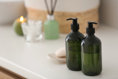 Photo of Green soap dispensers on white countertop in bathroom. Space for text