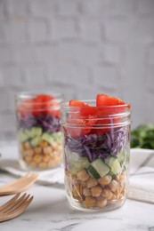 Healthy salad in glass jars on marble table