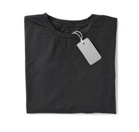 Photo of Stylish black T-shirt with label isolated on white, top view