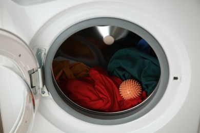 Photo of Dryer ball and clothes in washing machine, closeup