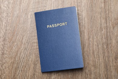 Blank blue passport on wooden table, top view
