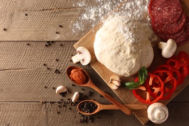 Photo of Pizza dough and products on wooden table, flat lay. Space for text