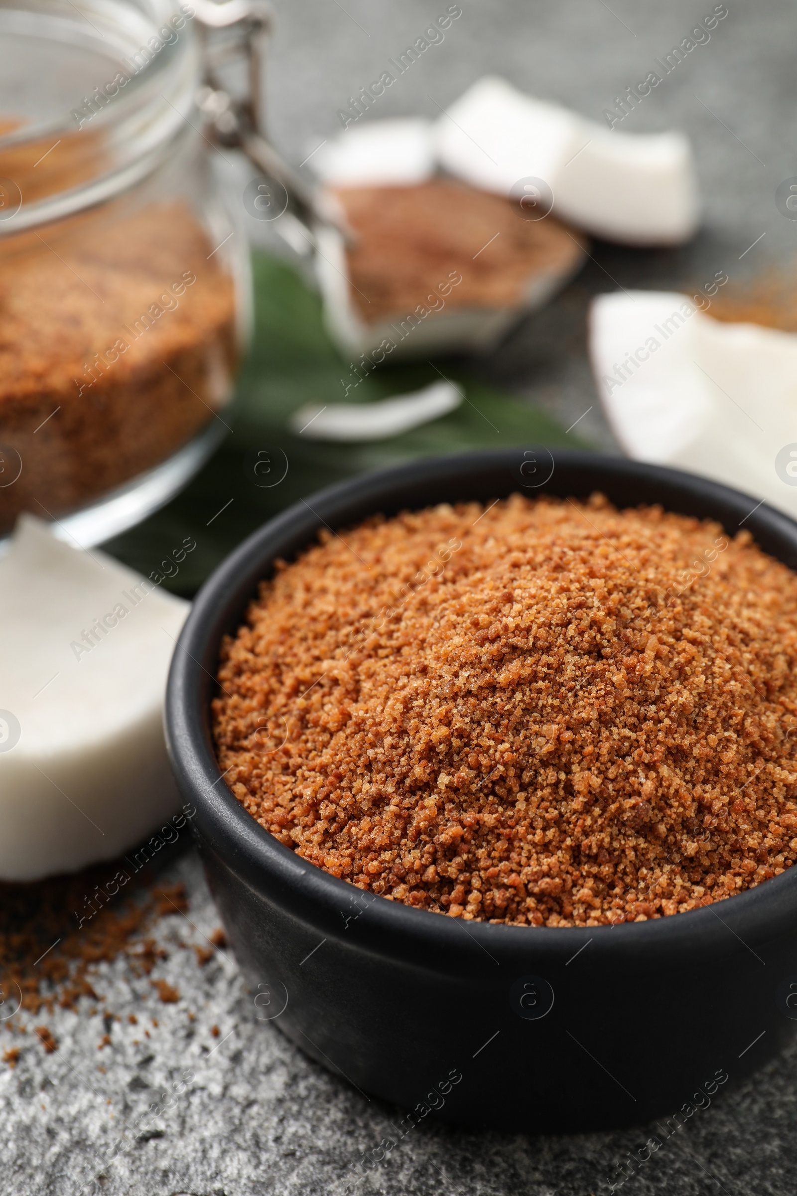 Photo of Natural coconut sugar in bowl on grey table