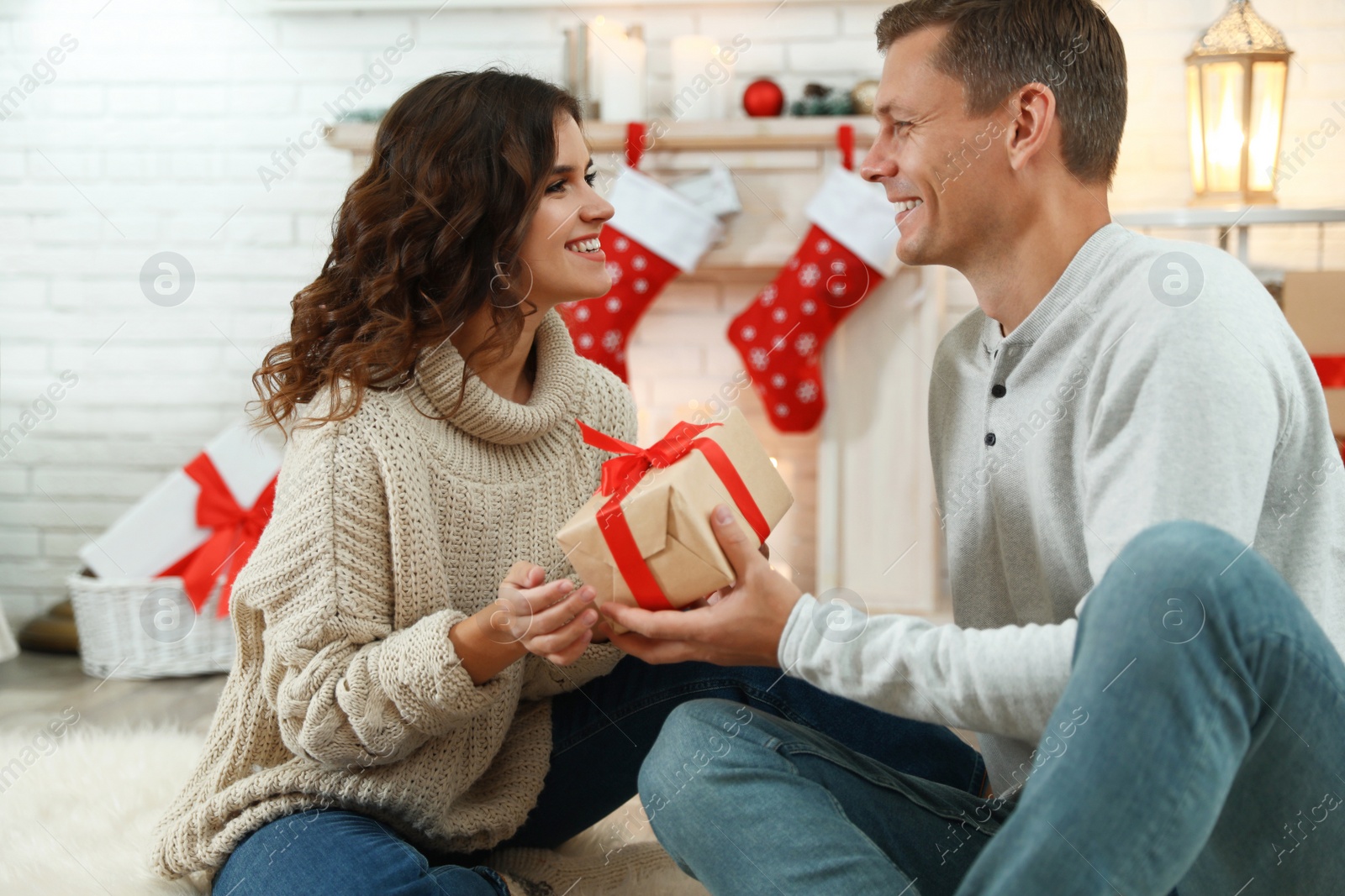 Image of Happy couple with Christmas gift at home