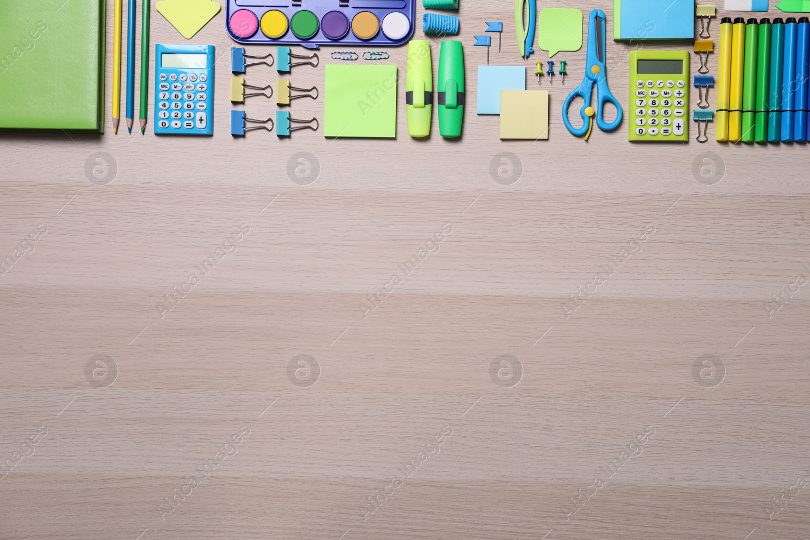 Photo of Different school stationery on wooden table, flat lay. Space for text