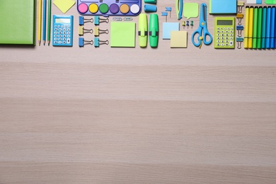 Different school stationery on wooden table, flat lay. Space for text