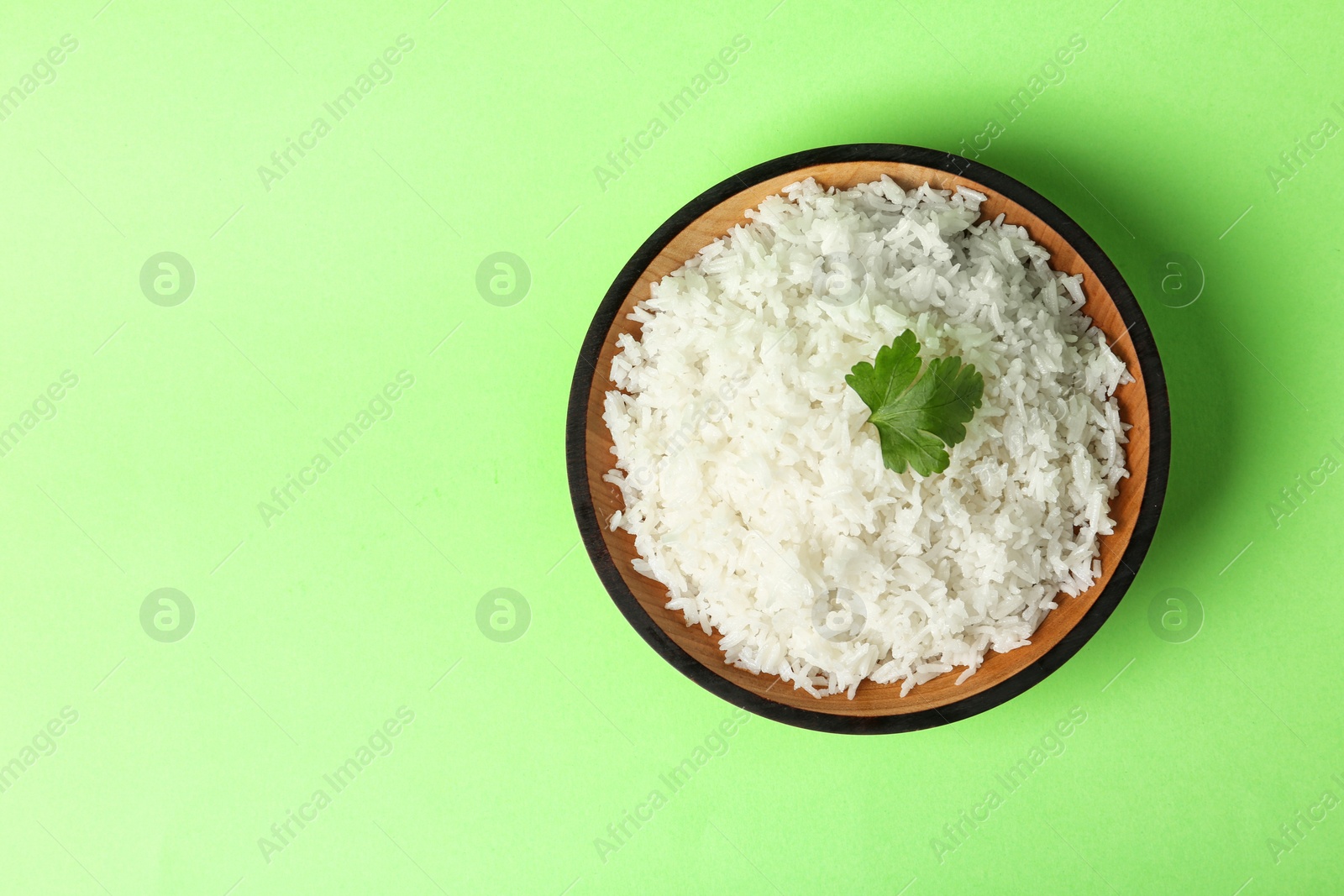 Photo of Bowl of boiled rice on color background, top view with space for text