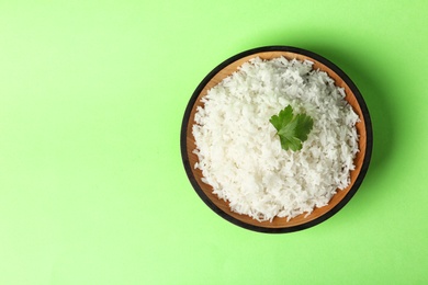 Photo of Bowl of boiled rice on color background, top view with space for text