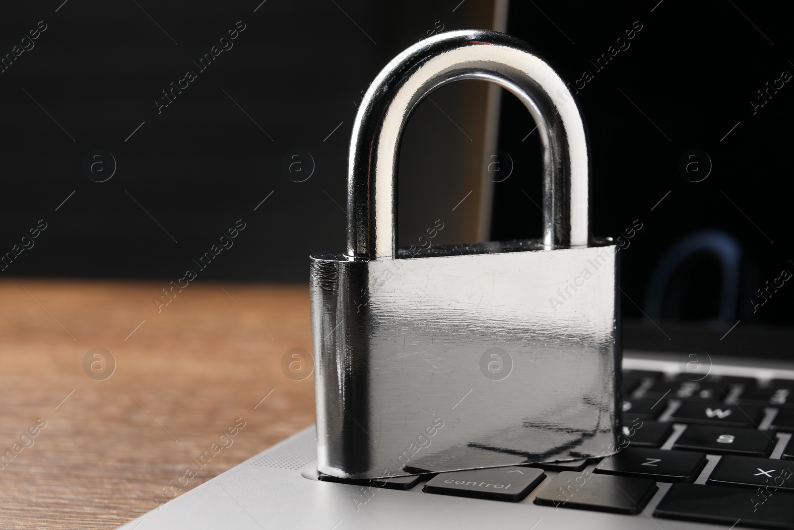 Photo of Cyber security. Laptop with padlock on table, closeup and space for text