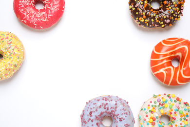 Delicious glazed donuts on white background, flat lay. Space for text